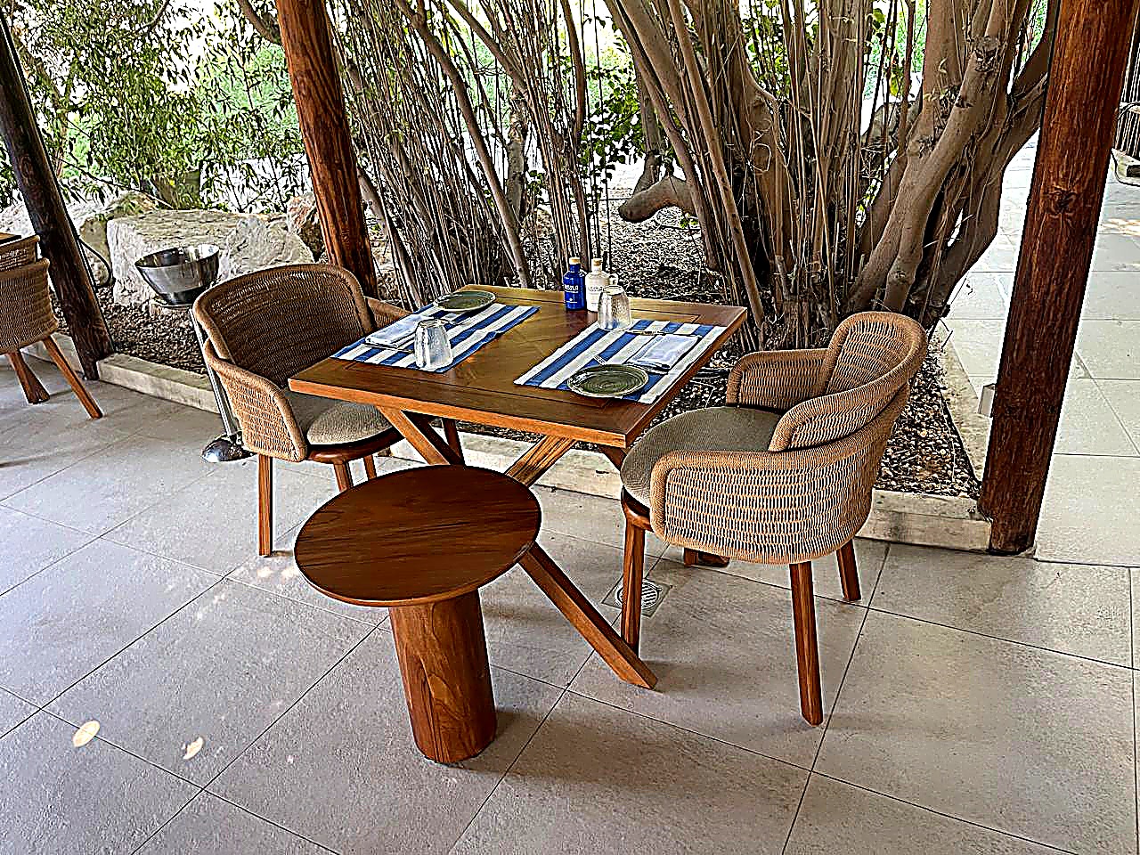 Outdoor rope-weave dining chairs and teak table, hotel terrace furniture UAE