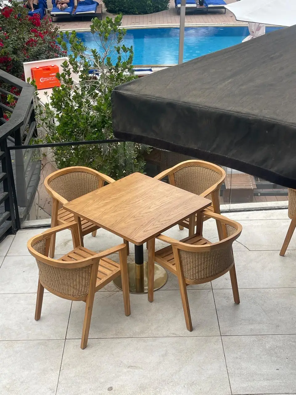 Outdoor restaurant terrace in Dubai with rope-weave armchairs, cushions and powder-coated slatted dining tables