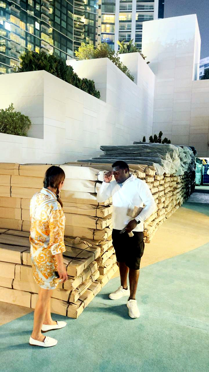 Leadership inspecting delivered outdoor teak furniture on site at a beachfront resort, Dubai