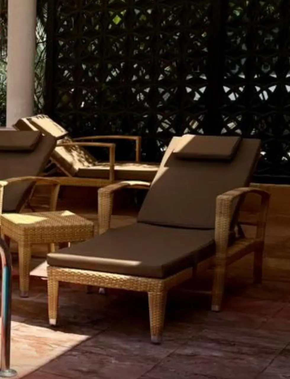 Row of centre-pole umbrellas and sunloungers along the waterfront, Abu Dhabi resort