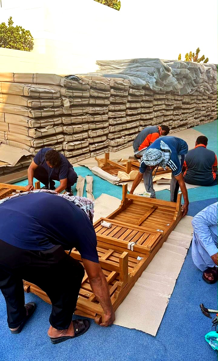 N&B team assembling teak sunloungers on site at a beachfront resort, Dubai