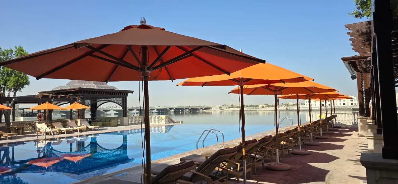 Centre-pole pool umbrellas at a five-star resort infinity pool, Abu Dhabi