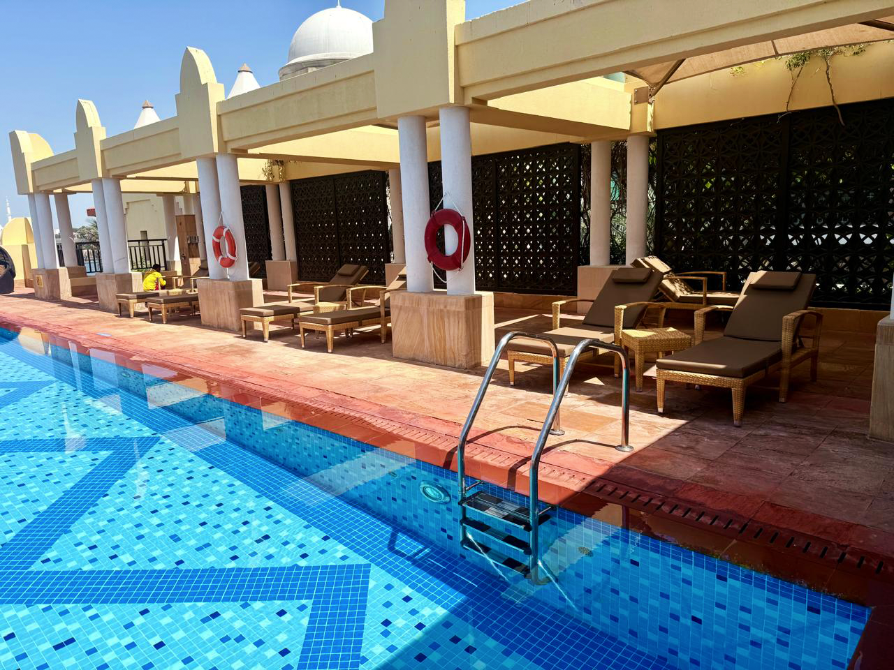 Poolside deck with custom outdoor loungers and canopy shading at a five-star resort, Abu Dhabi